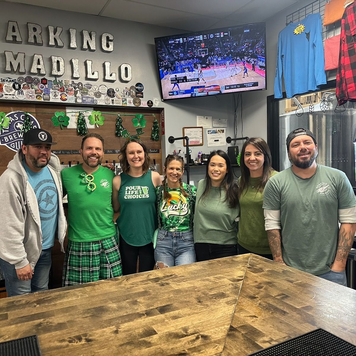 A group of bartenders standing together behind a bar.