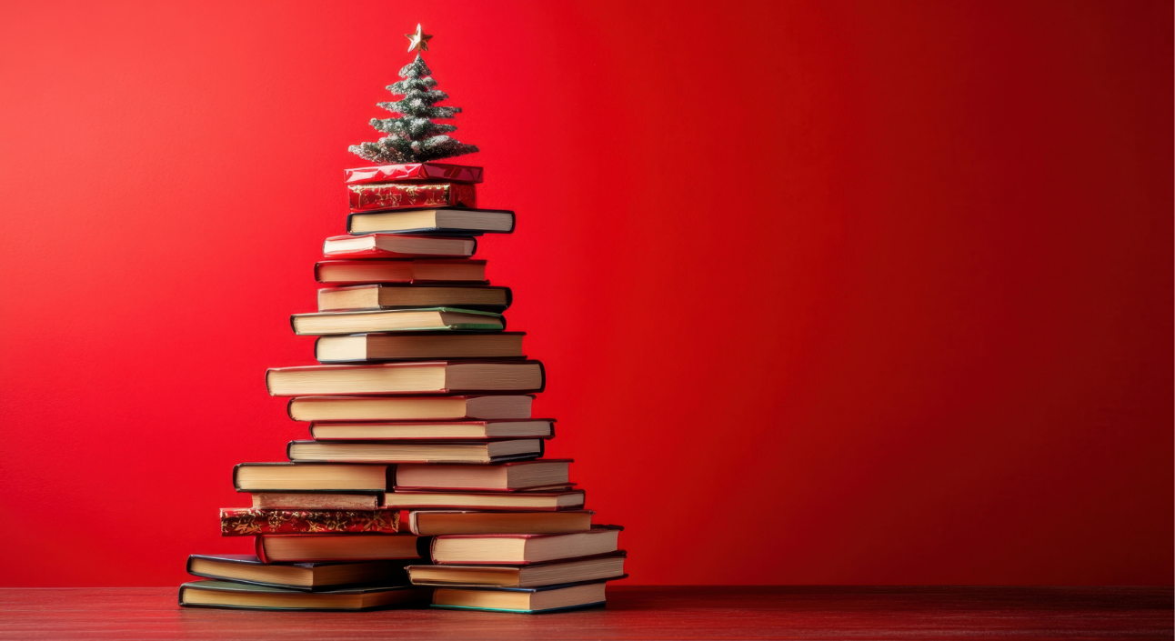 Christmas tree made of books with a small tree on top, against a red background.
