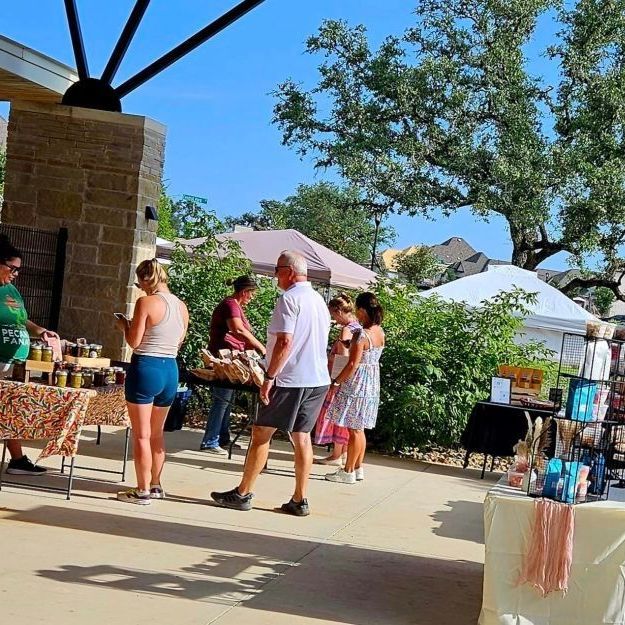 People walking around at an outdoor market 