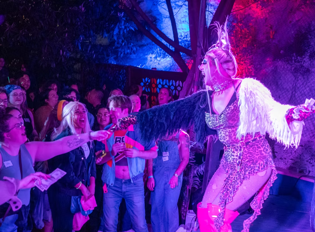 Performer interacting with an excited crowd at a colorful queer event in Austin, Texas