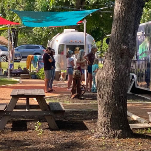 An outdoor market with tents and trees