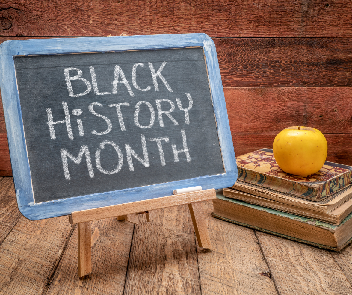 image of a small blackboard with text black history month alongside a stack of books 