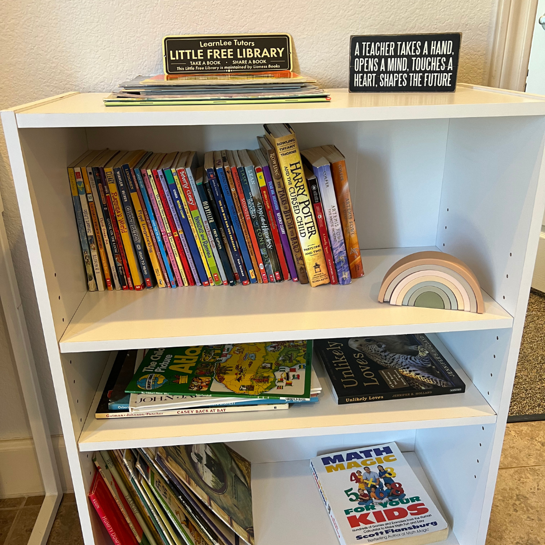 A bookshelf full of free books and a sign for Little Free Library at the top