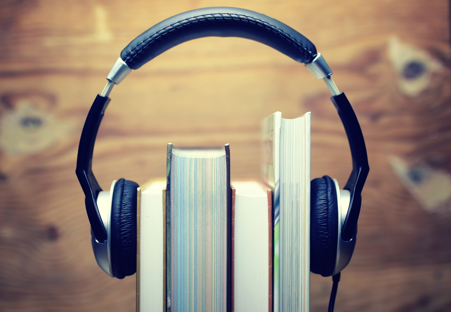 A pair of headphones sitting on top of a stack of books.