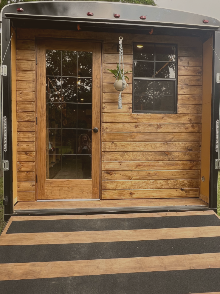 A trailer with a wooden door and window