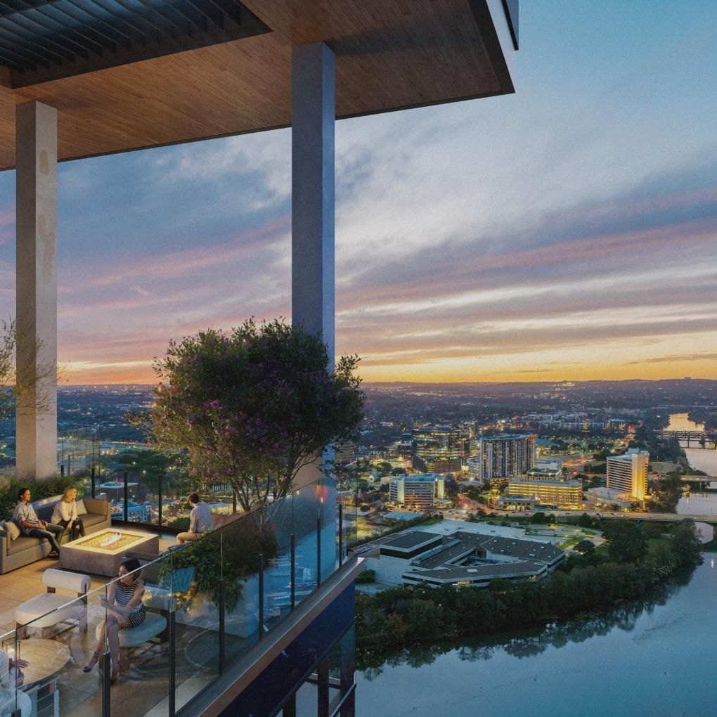 The outside view of a balcony overlooking a river and a city
