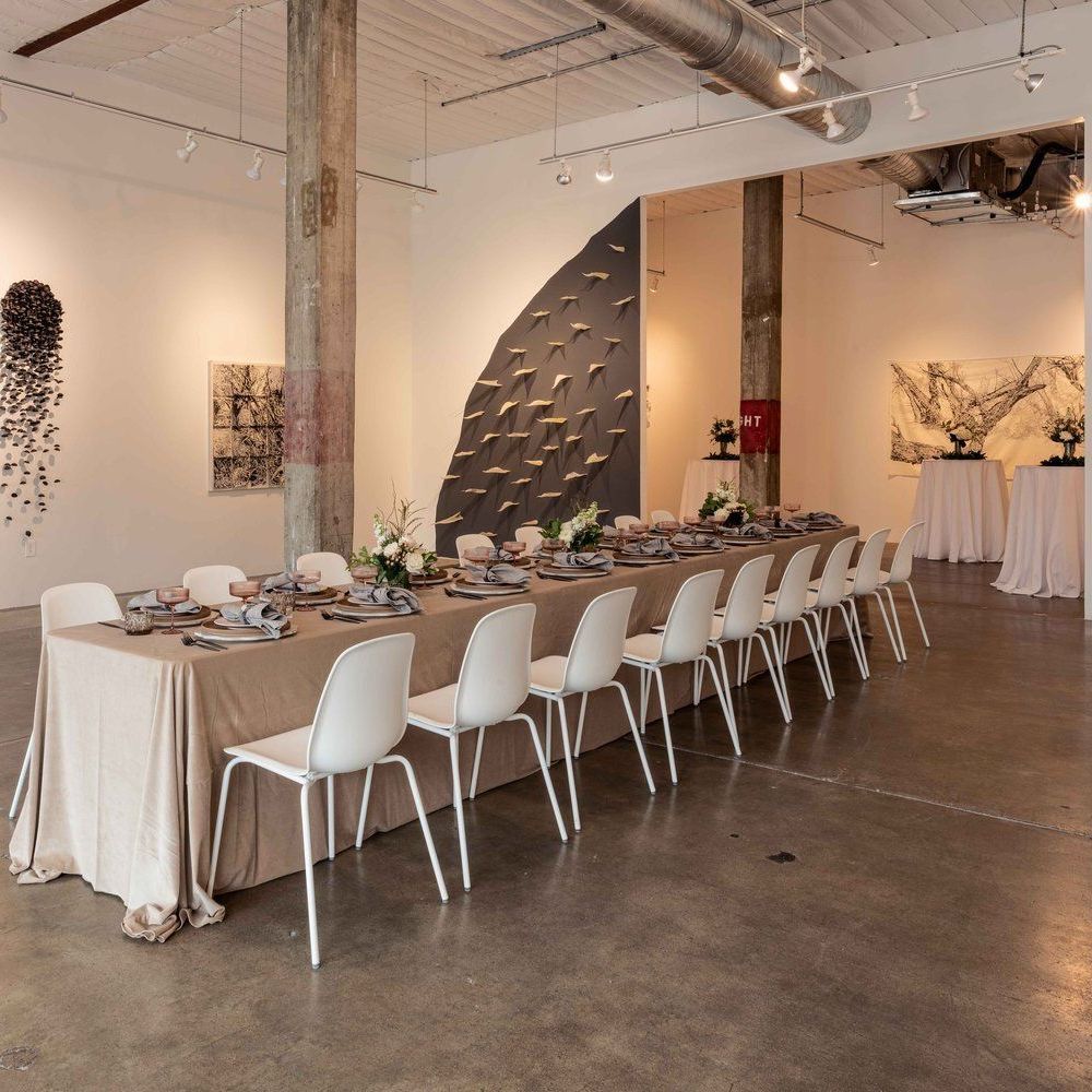 A decorative indoor space with a long table and white chairs