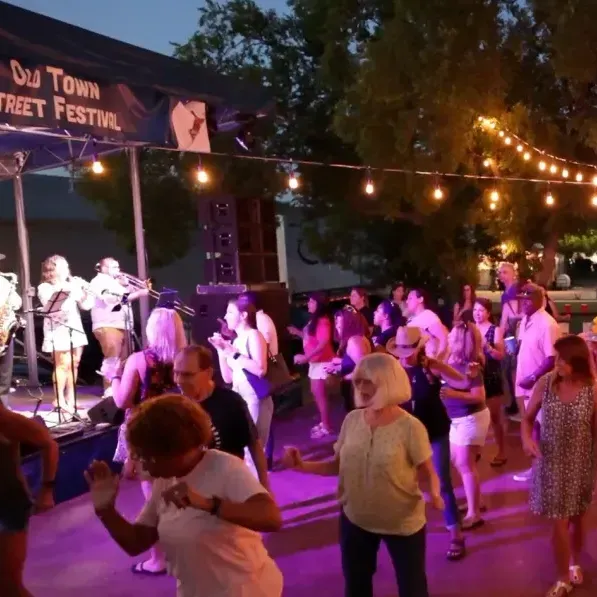 A crowd of people next to a stage at a festival