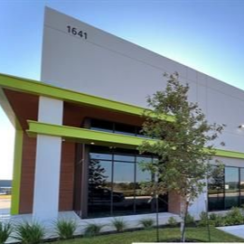 Modern building exterior with green trim, large windows, and the number 1641 above the roofline