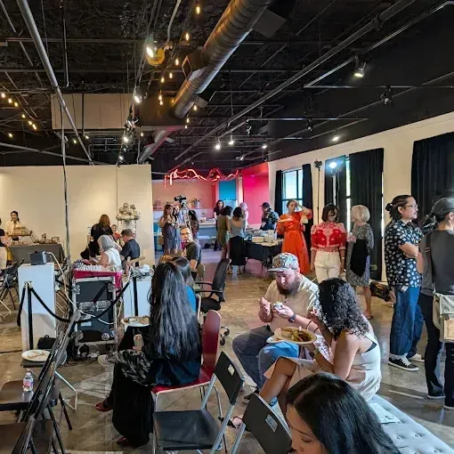 An indoor studio space with people mingling