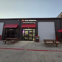 The outside view of a brewery with black and red accents