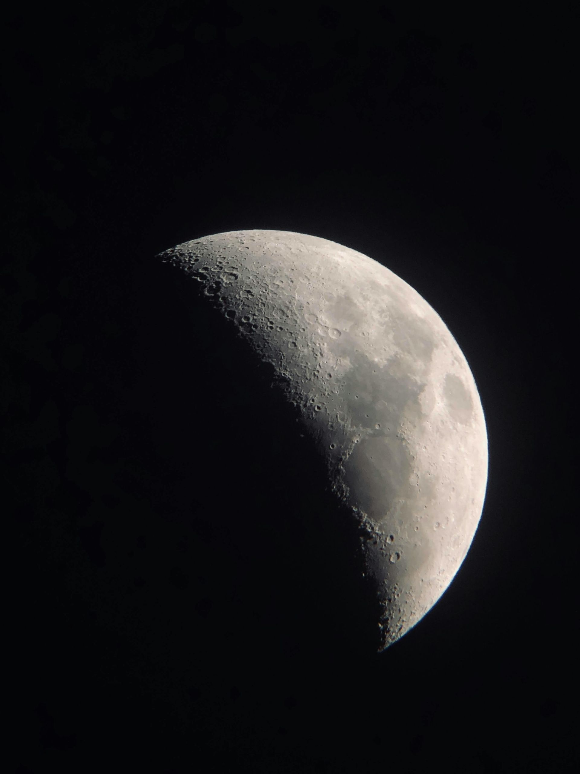 Waning moon, showing craters and shadowed surface against a dark sky.