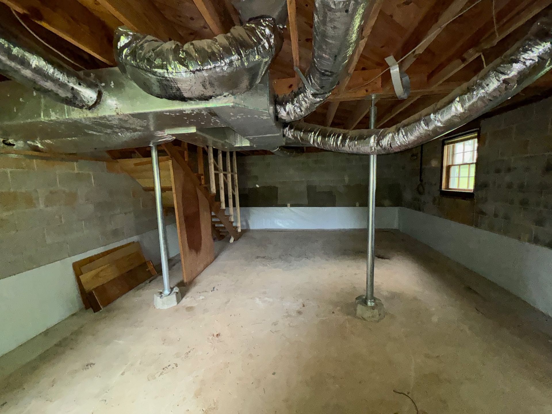 An empty basement with a lot of pipes coming out of the ceiling.