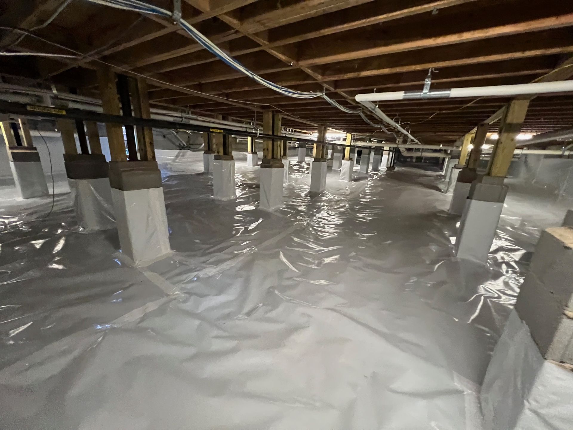 The foundation of a house is covered in plastic.