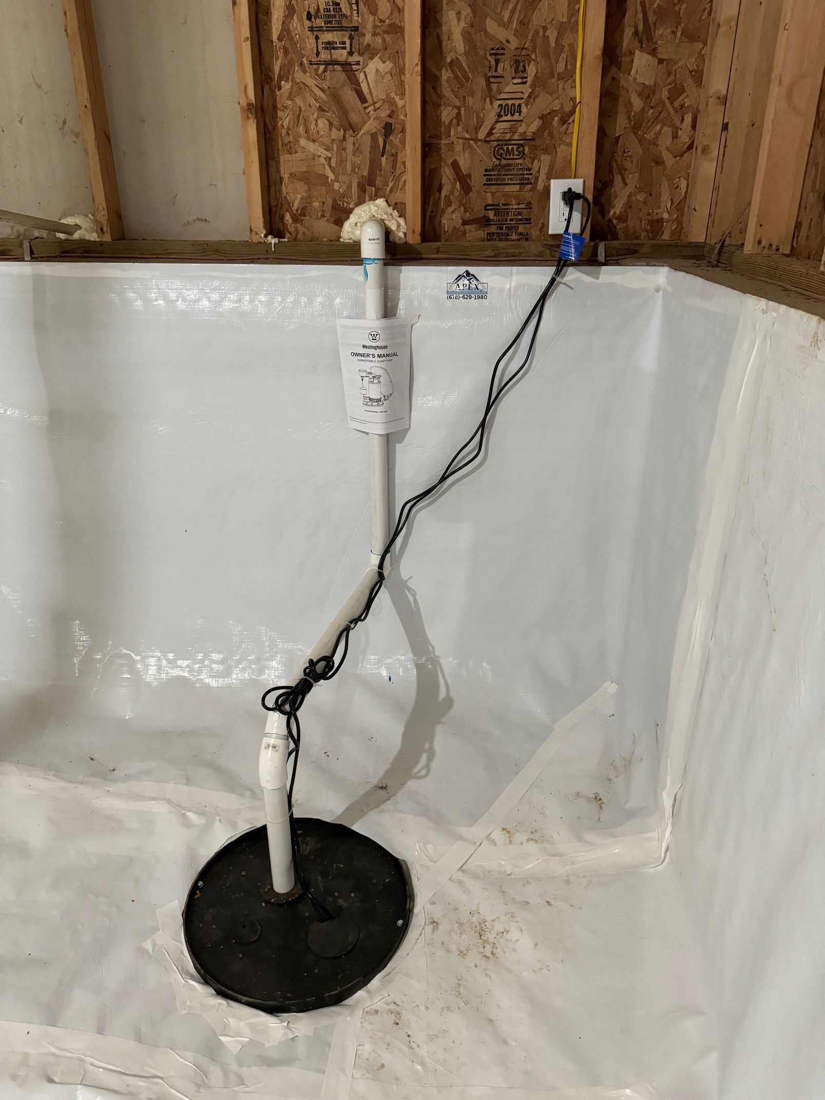 A drain in a basement with a hose attached to it.