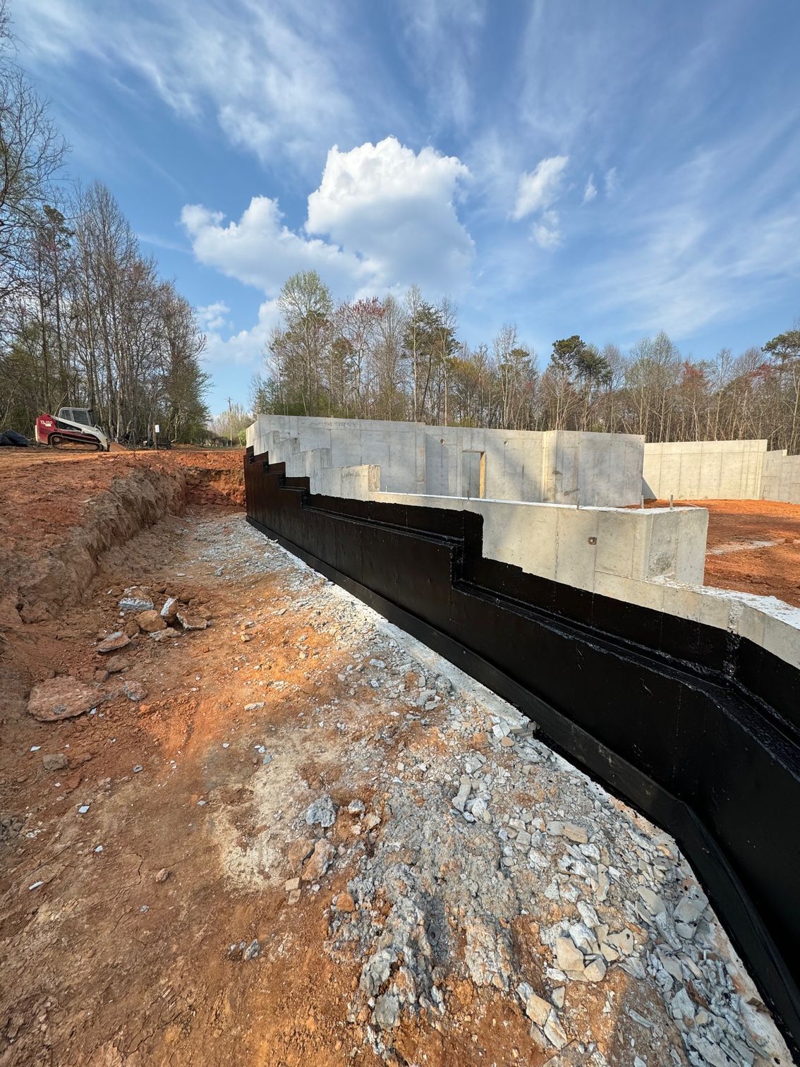 A concrete wall is being built in a dirt field.