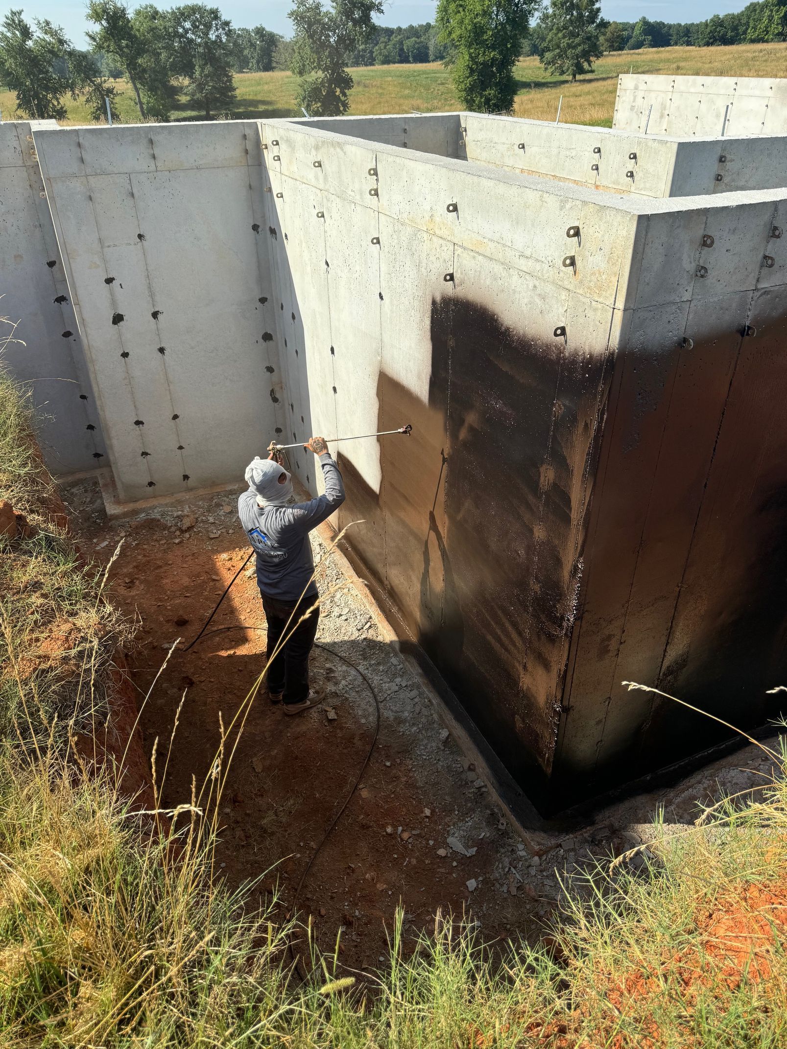 A man is spraying paint on a concrete wall