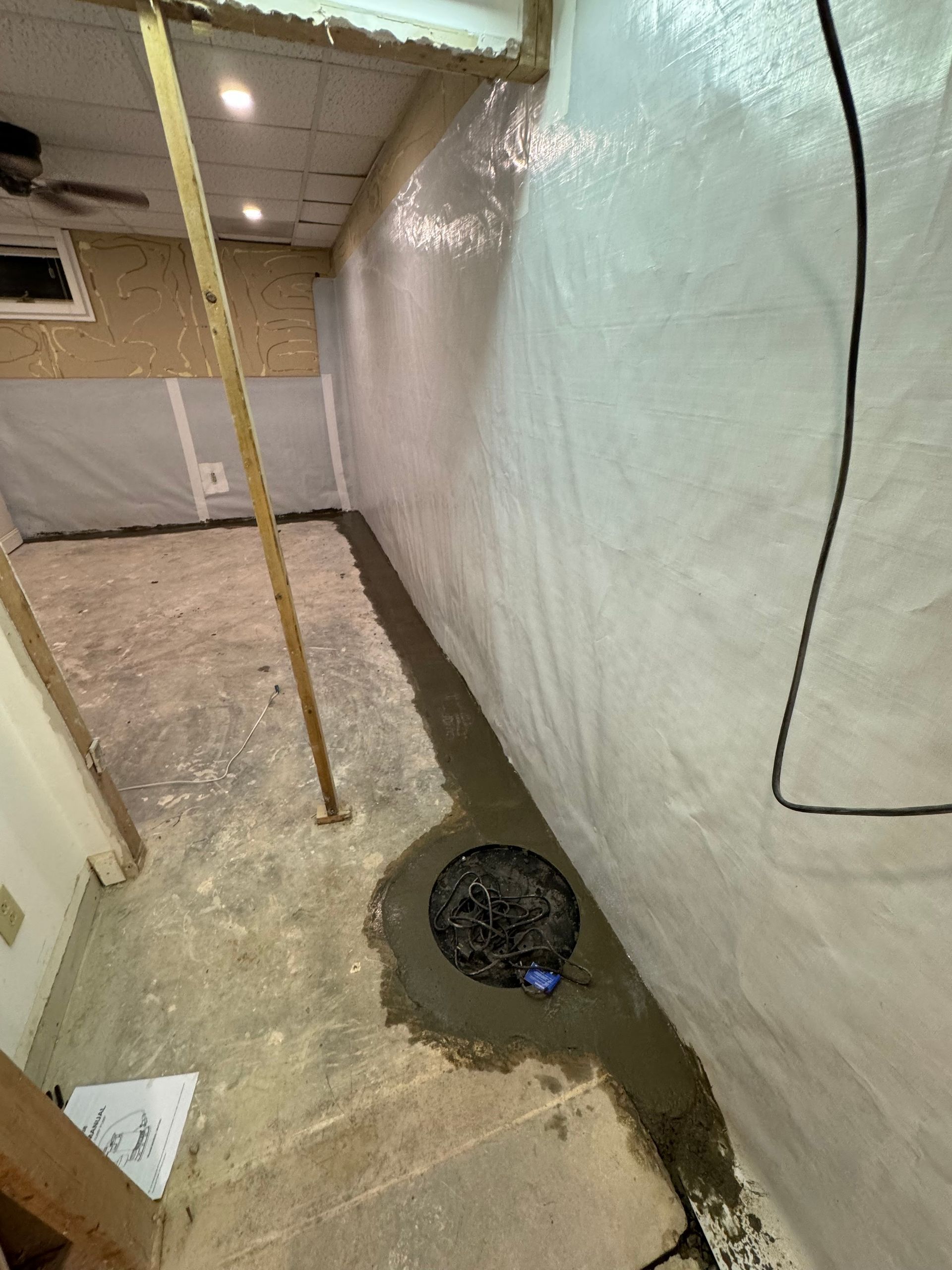Basement with waterproofed walls, a sump pump, and a perimeter drainage system.