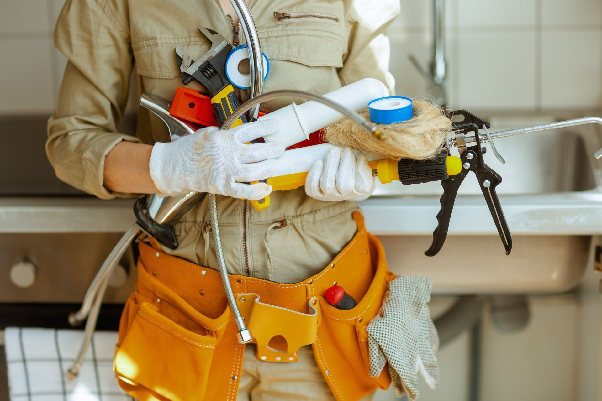 A plumber holds plumbing tools, including wrenches, pipes and tape, required for plumbing services.