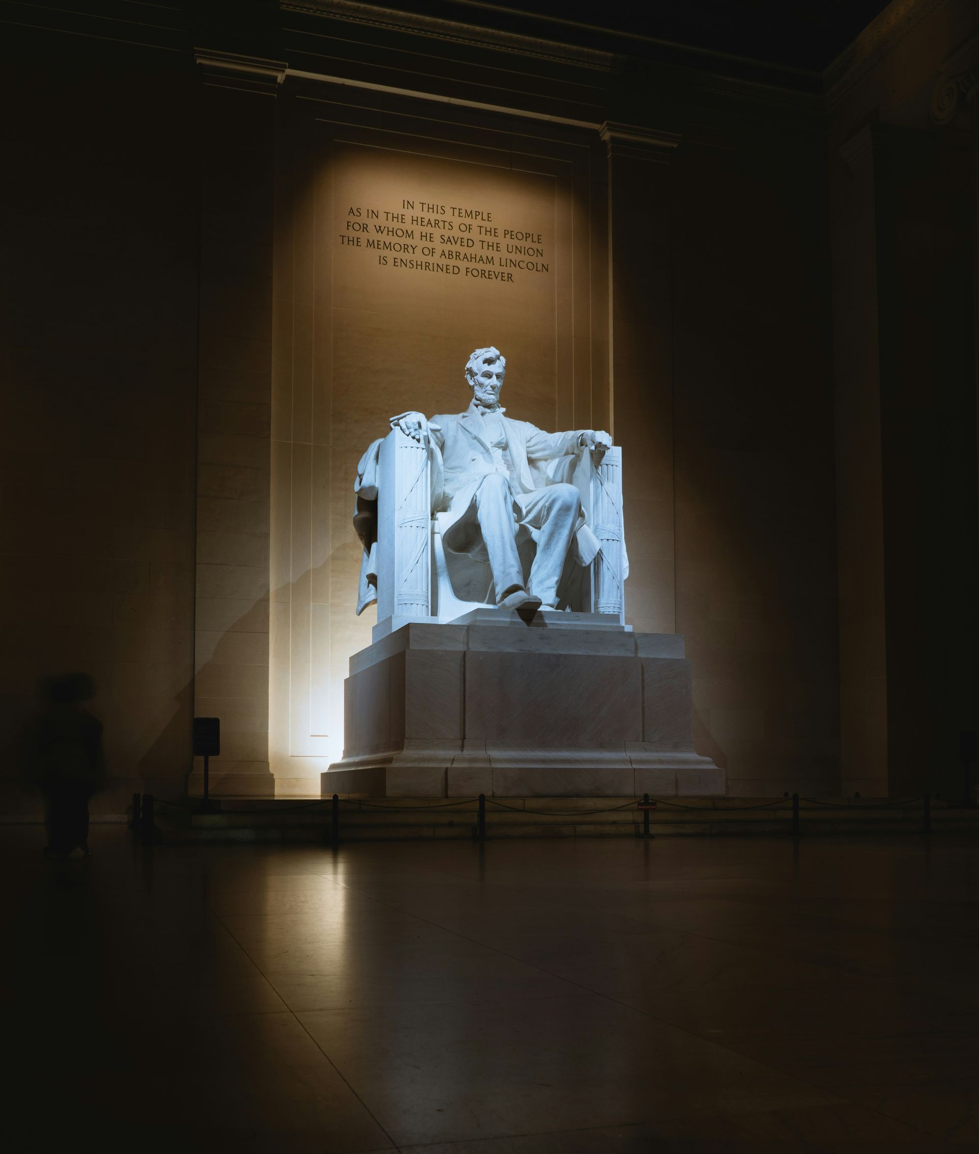 A statue of abraham lincoln sits in a dark room