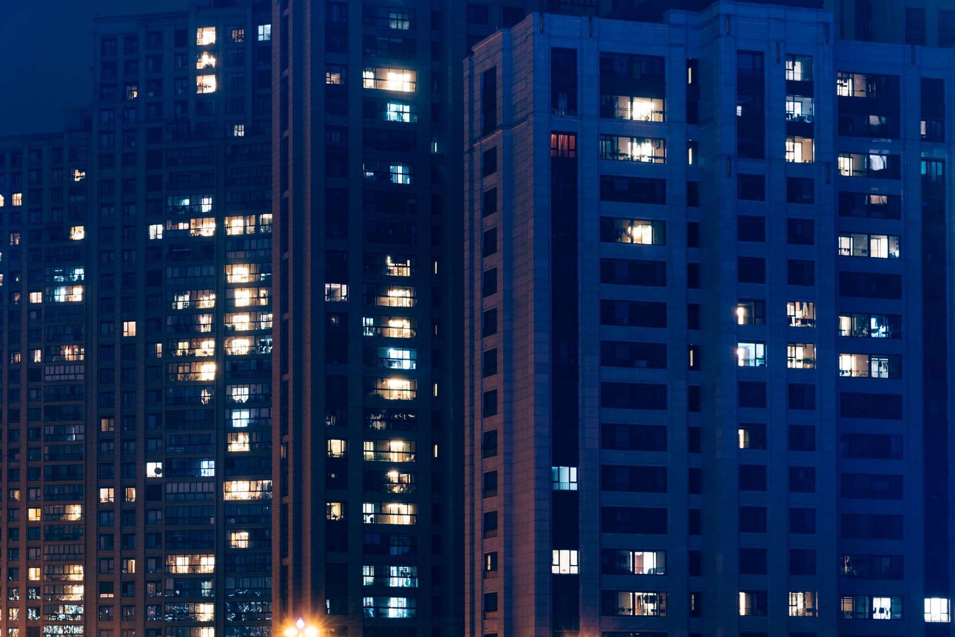 A row of tall buildings are lit up at night