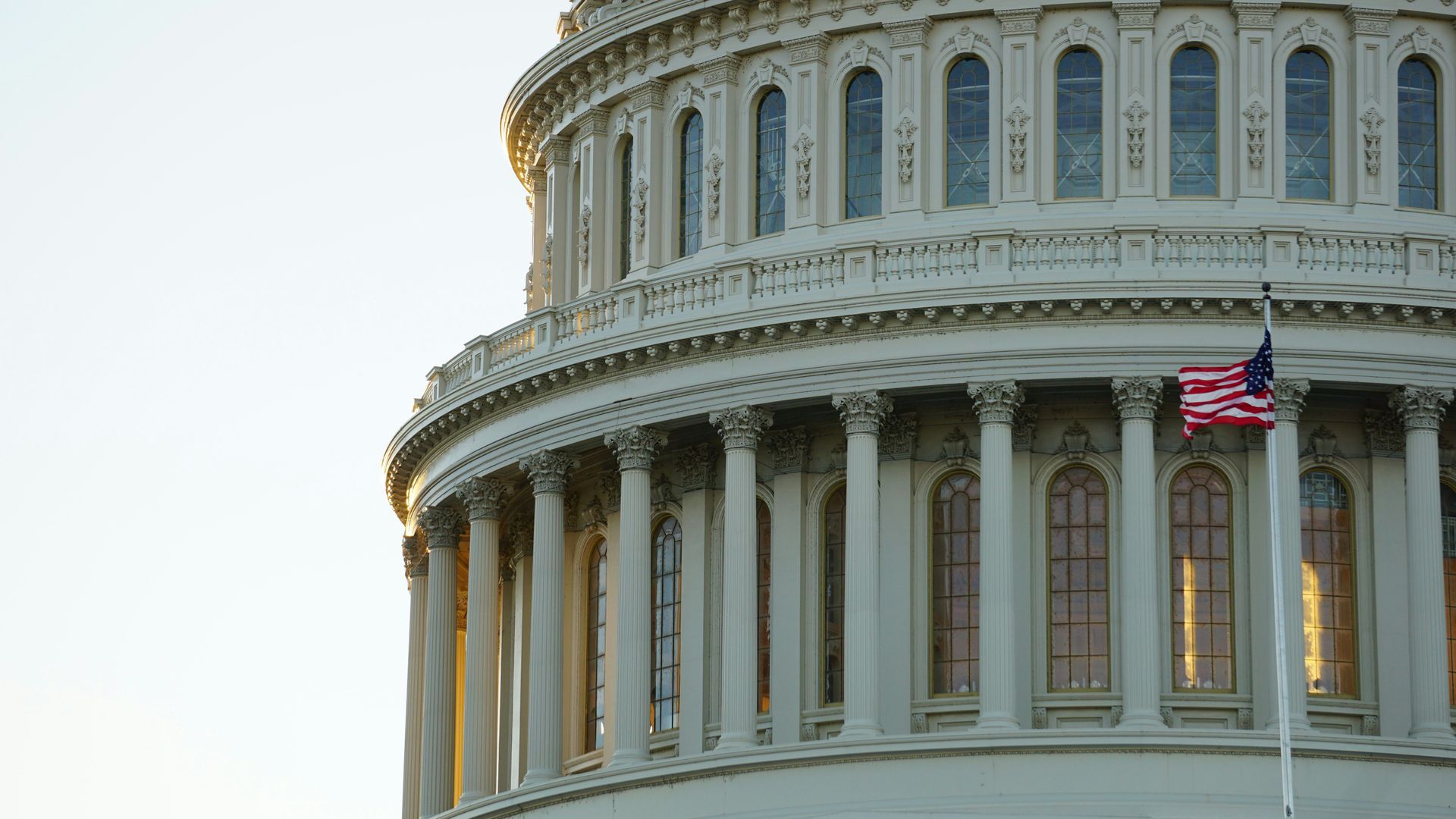 The capitol building in washington d.c. with an american flag flying in front of it.