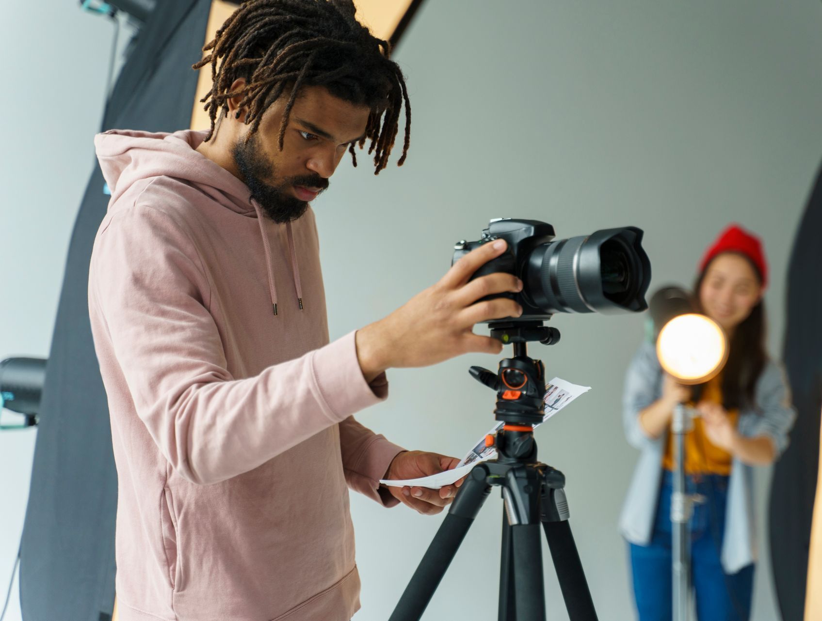 A man is taking a picture with a camera on a tripod.