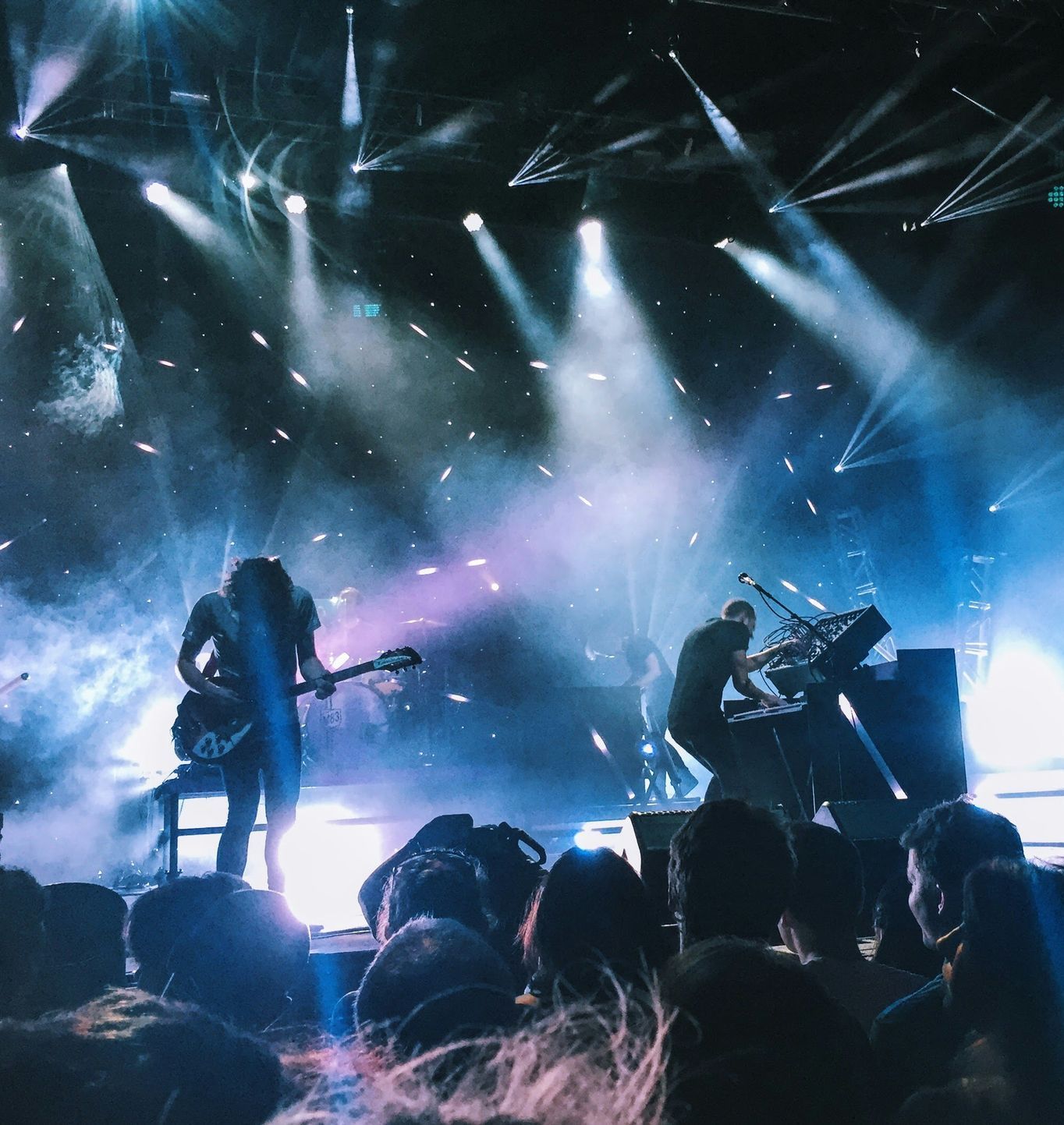 A group of people are watching a band perform on stage