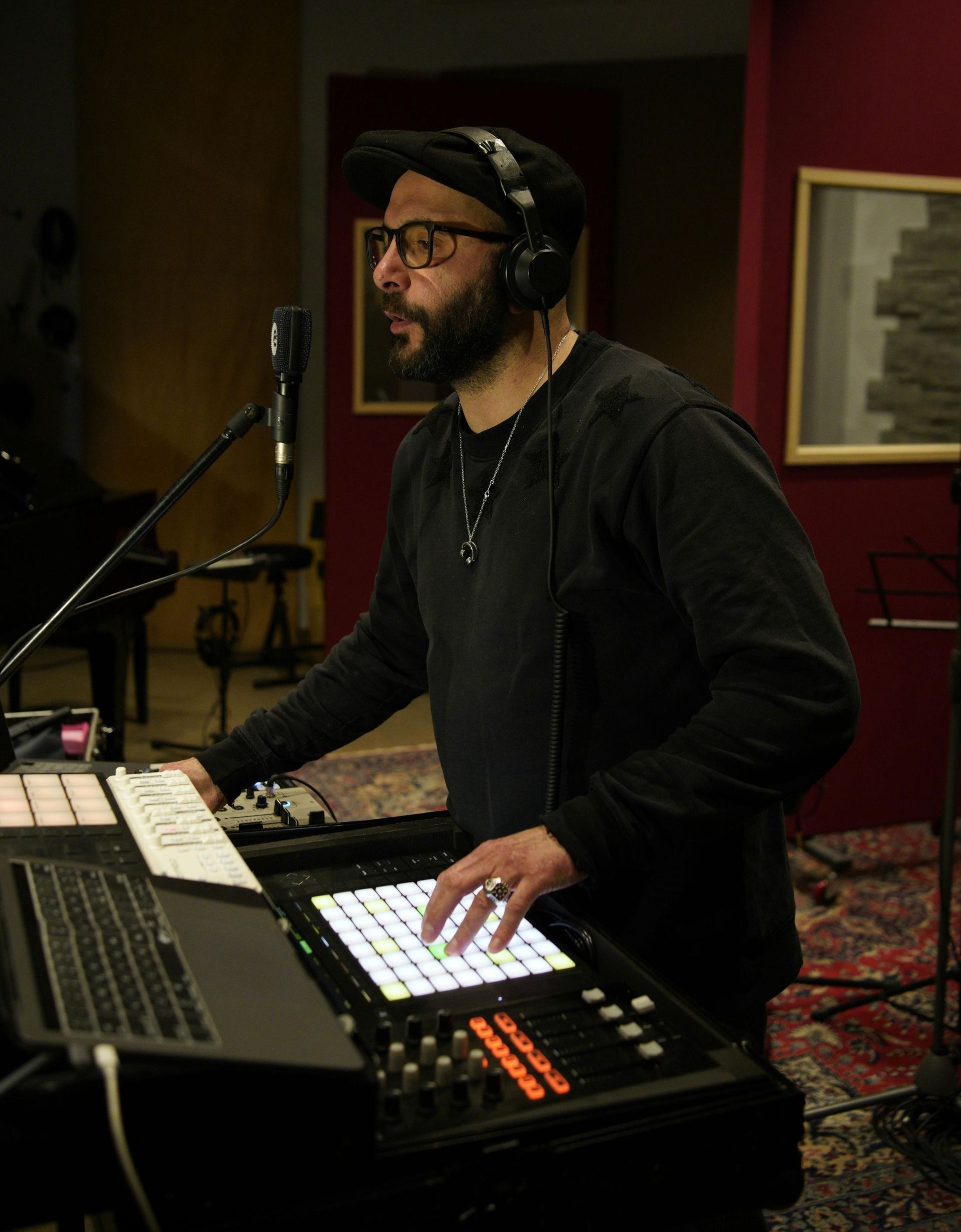 A man wearing headphones is playing a keyboard