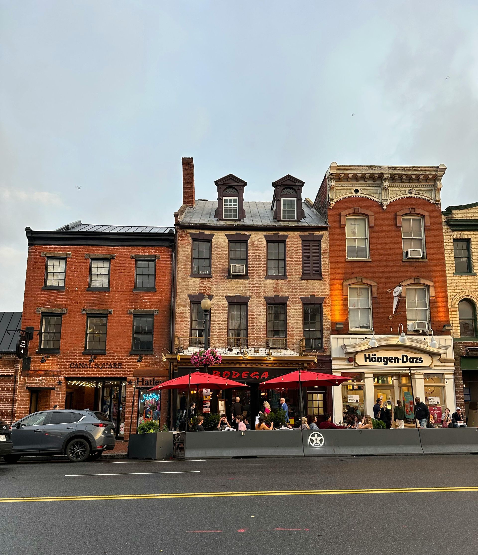 A row of brick buildings with umbrellas in front of them