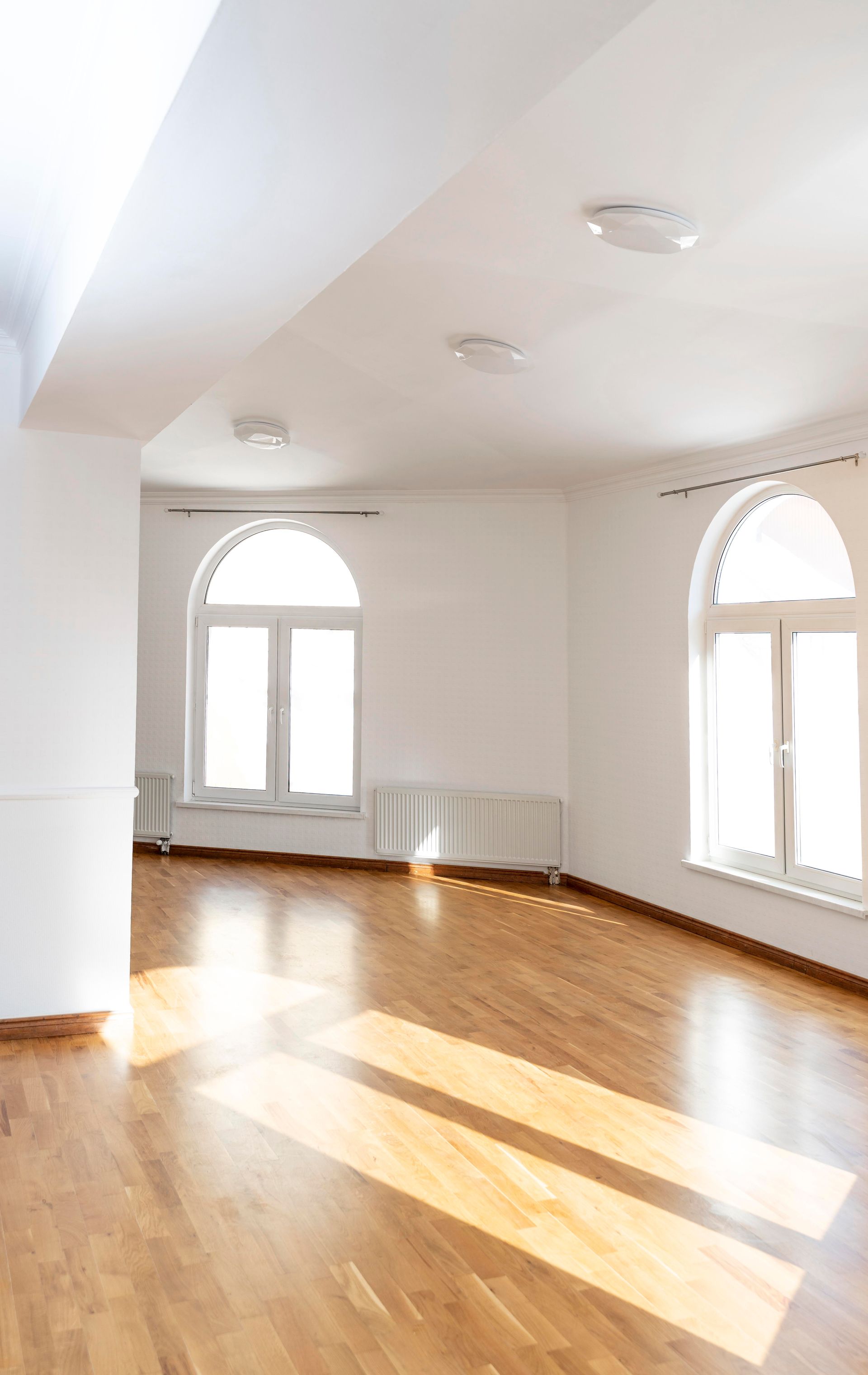 A large empty room with wooden floors and white walls.