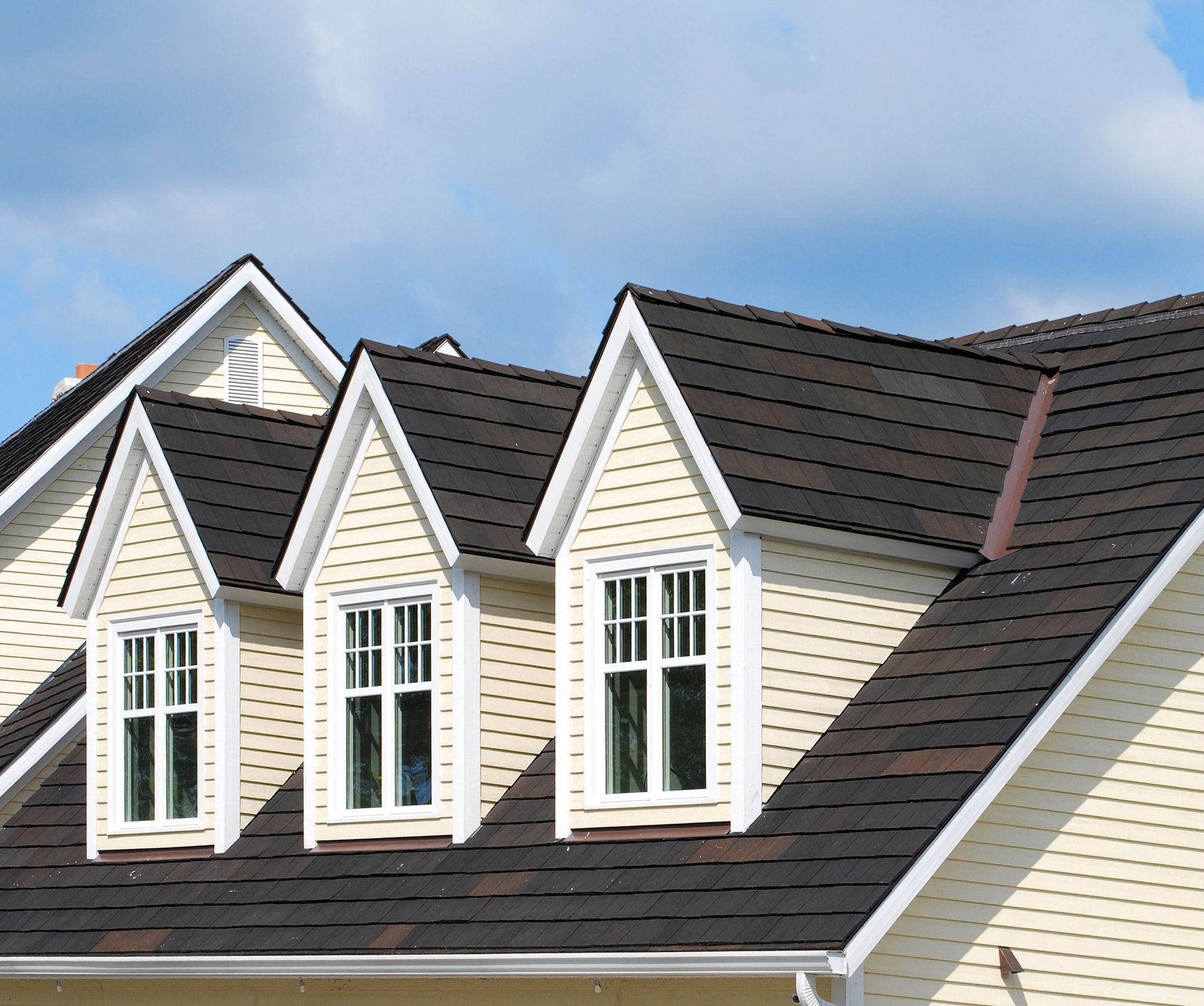 Image of a house with three windows and a roof, highlighting Shiloh Roofing's premium siding install