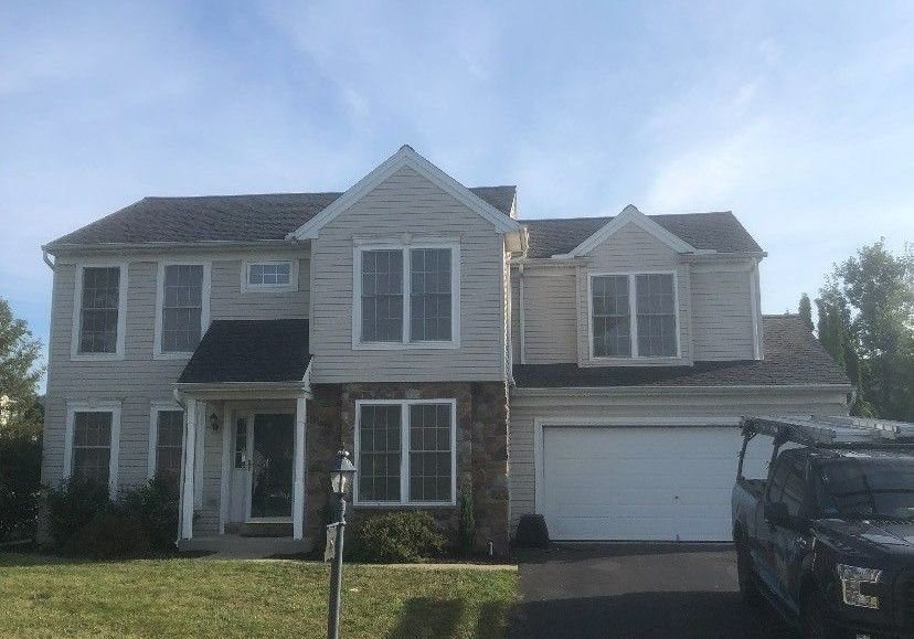 A large house with a truck parked in front of it.