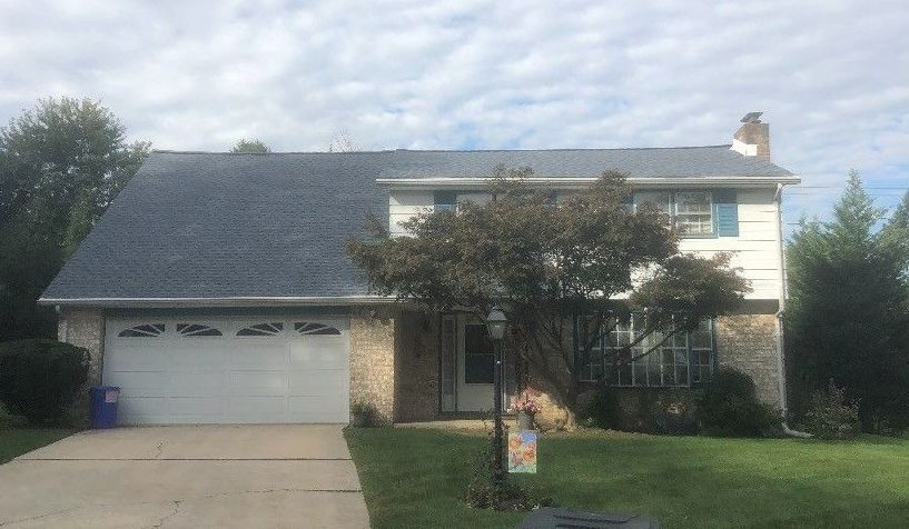 A large house with a gray roof and a white garage door.