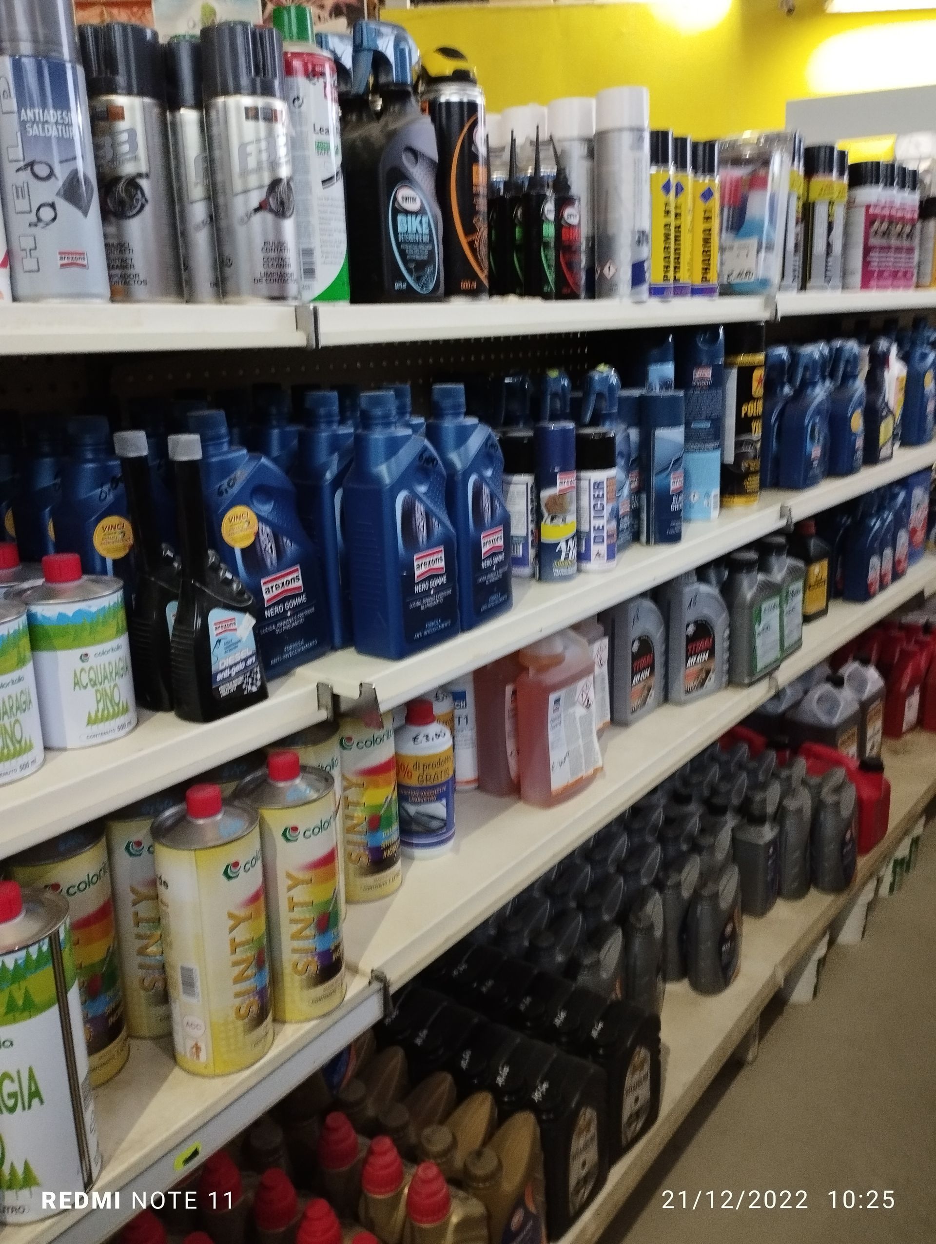 Uno scaffale di un negozio pieno di bottiglie e lattine