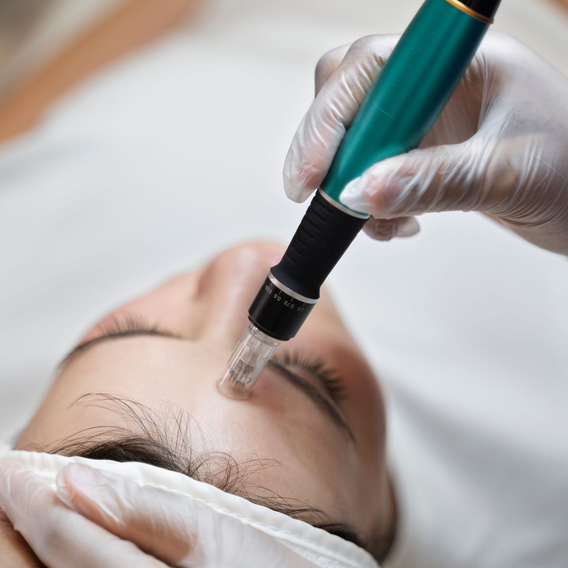 A person wearing gloves is using a pen on a woman 's face