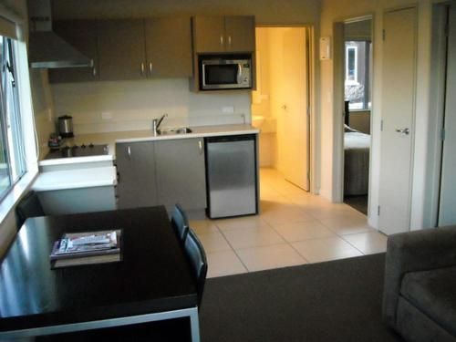 a kitchen with a table and chairs and a microwave .