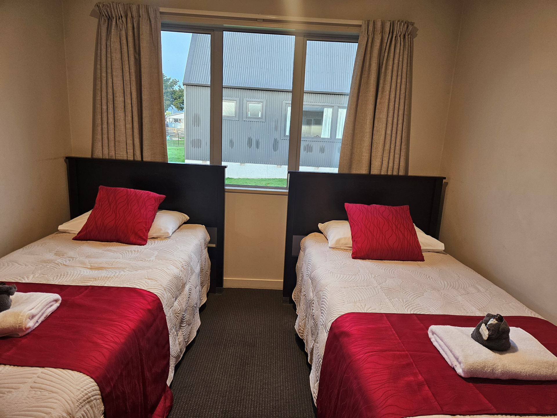 A hotel room with two beds and a window.