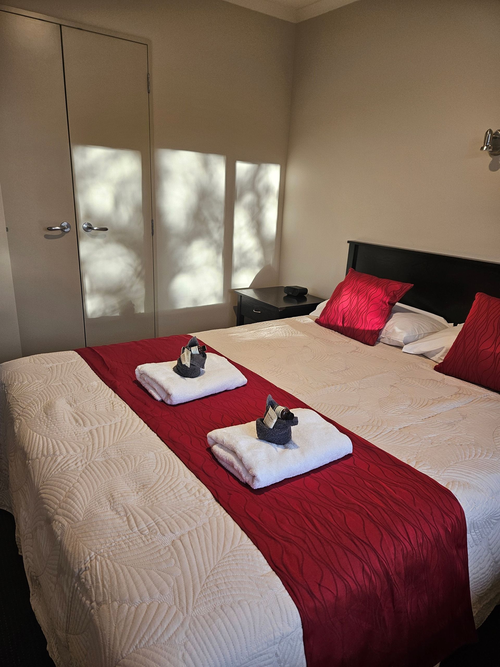 A hotel room with a bed and two towels on it