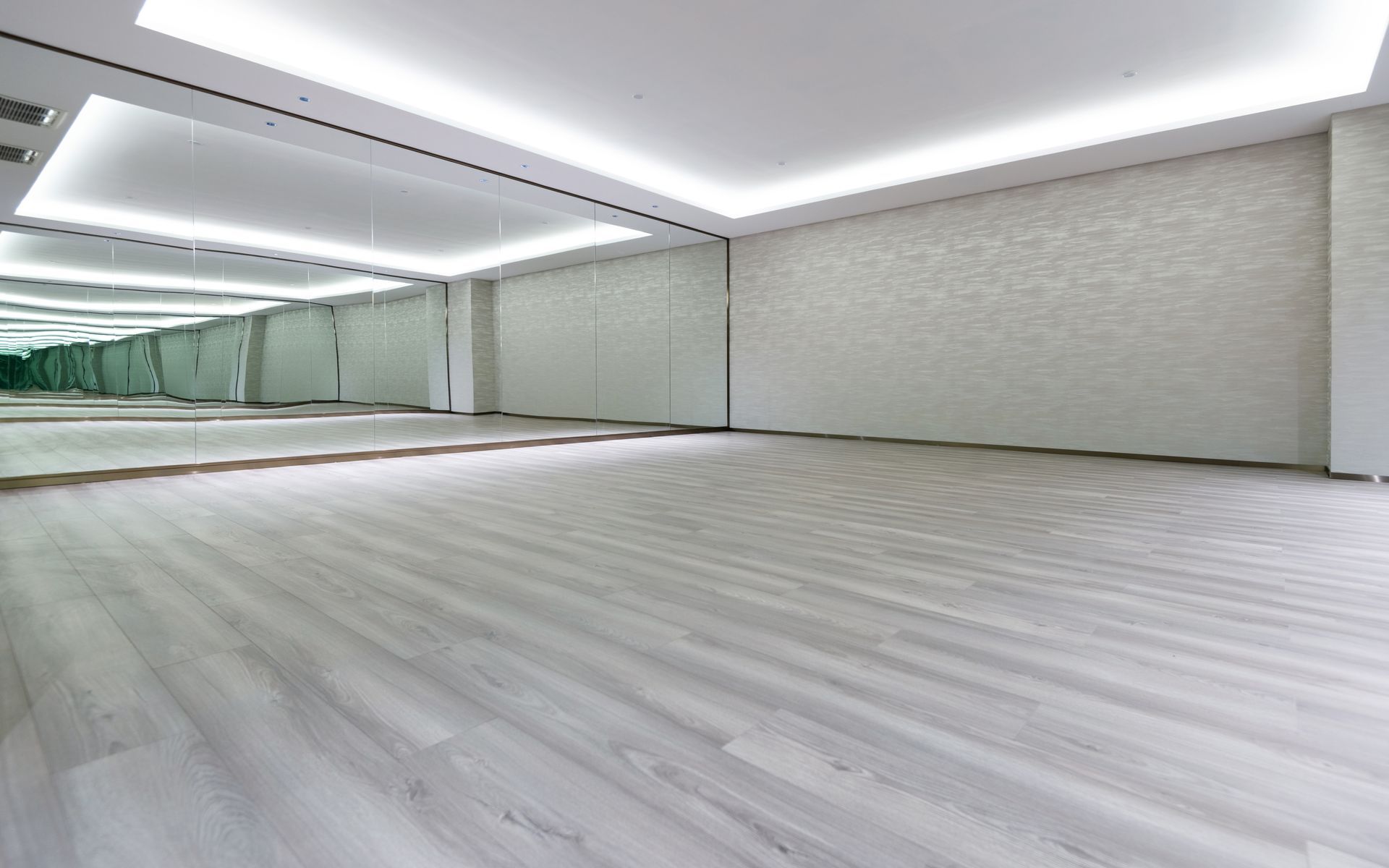 A large empty room with a lot of mirrors on the wall.