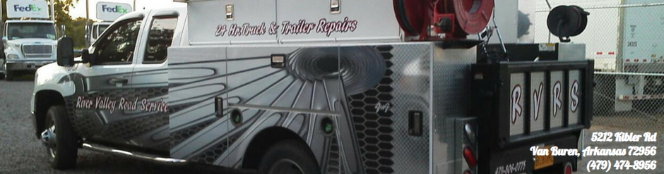 Silver and black bus with wing graphics parked outdoors, viewed from the side.