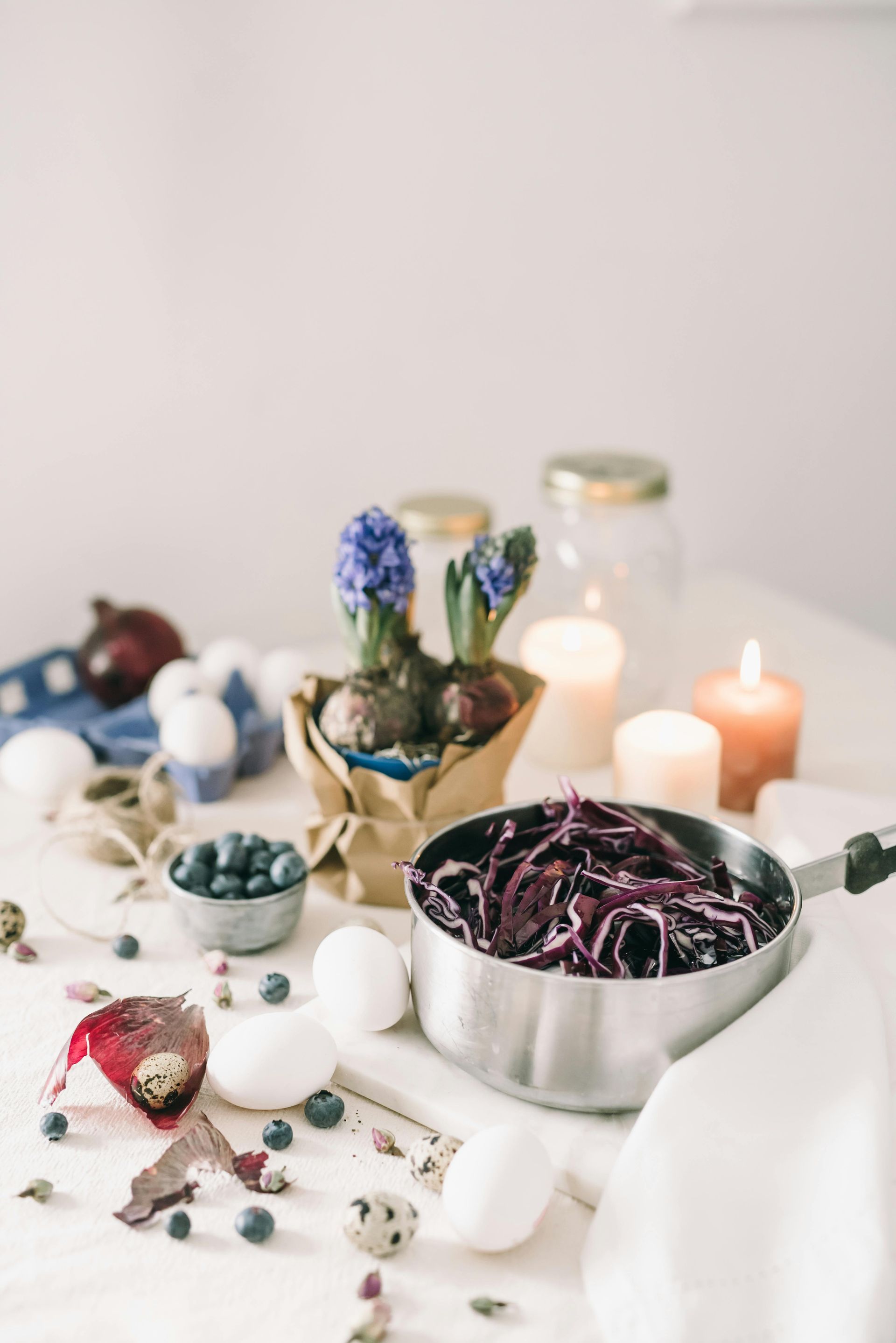 Table setting with purple shredded cabbage, eggs, flowers, and candles — All Body Holistic Health in Thuringowa Central, QLD