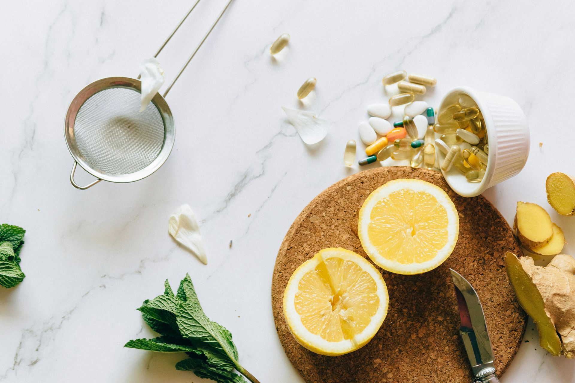 Lemon halves, pills, and herbs arranged on a marble surface — All Body Holistic Health in Thuringowa Central, QLD