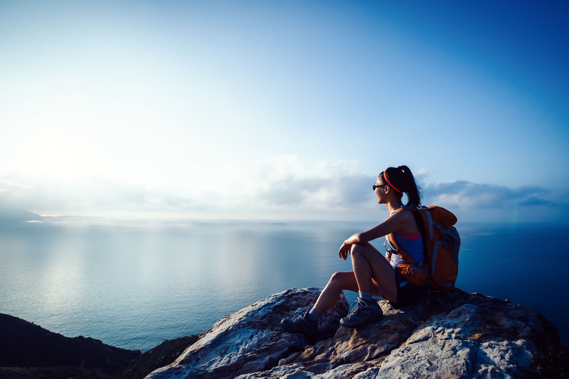 Person Sits on a Rock Overlooking Ocean — All Body Holistic Health in Thuringowa Central, QLD