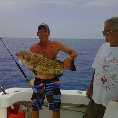 Man Holding a Brown Fish — Dania FL — Ironclad Welding