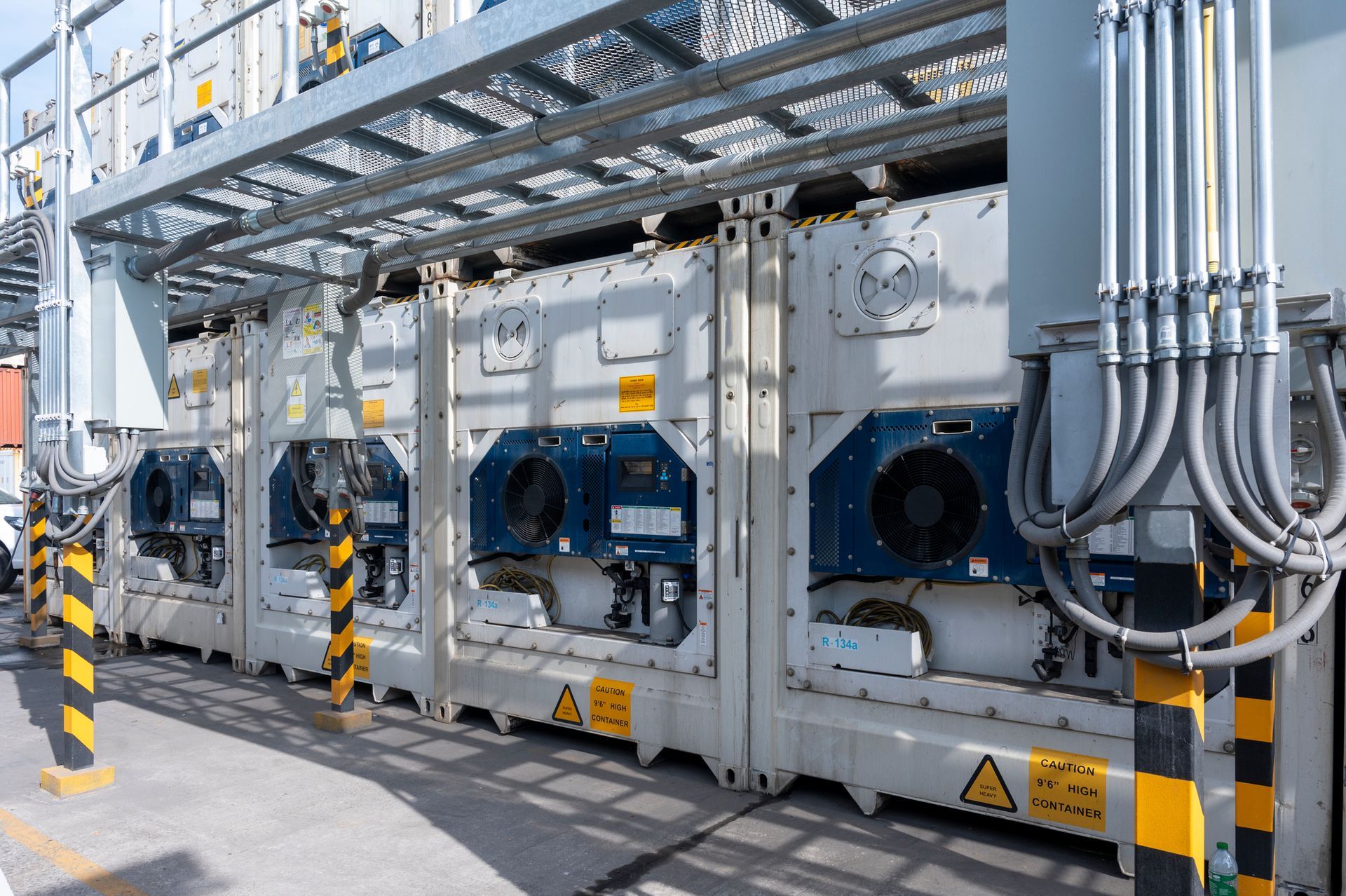 A row of shipping containers are lined up in a warehouse.