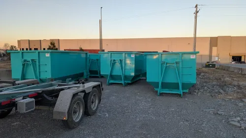A dumpster is parked in front of a best buy store.