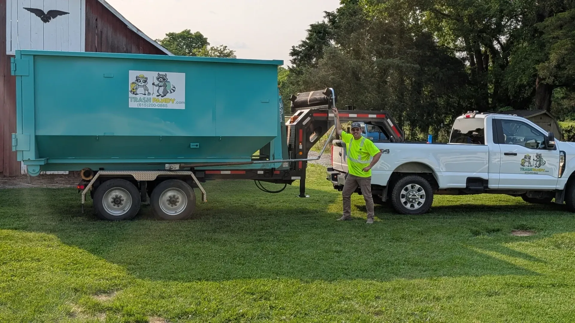 A dump truck with a green dumpster attached to it is parked in a parking lot.