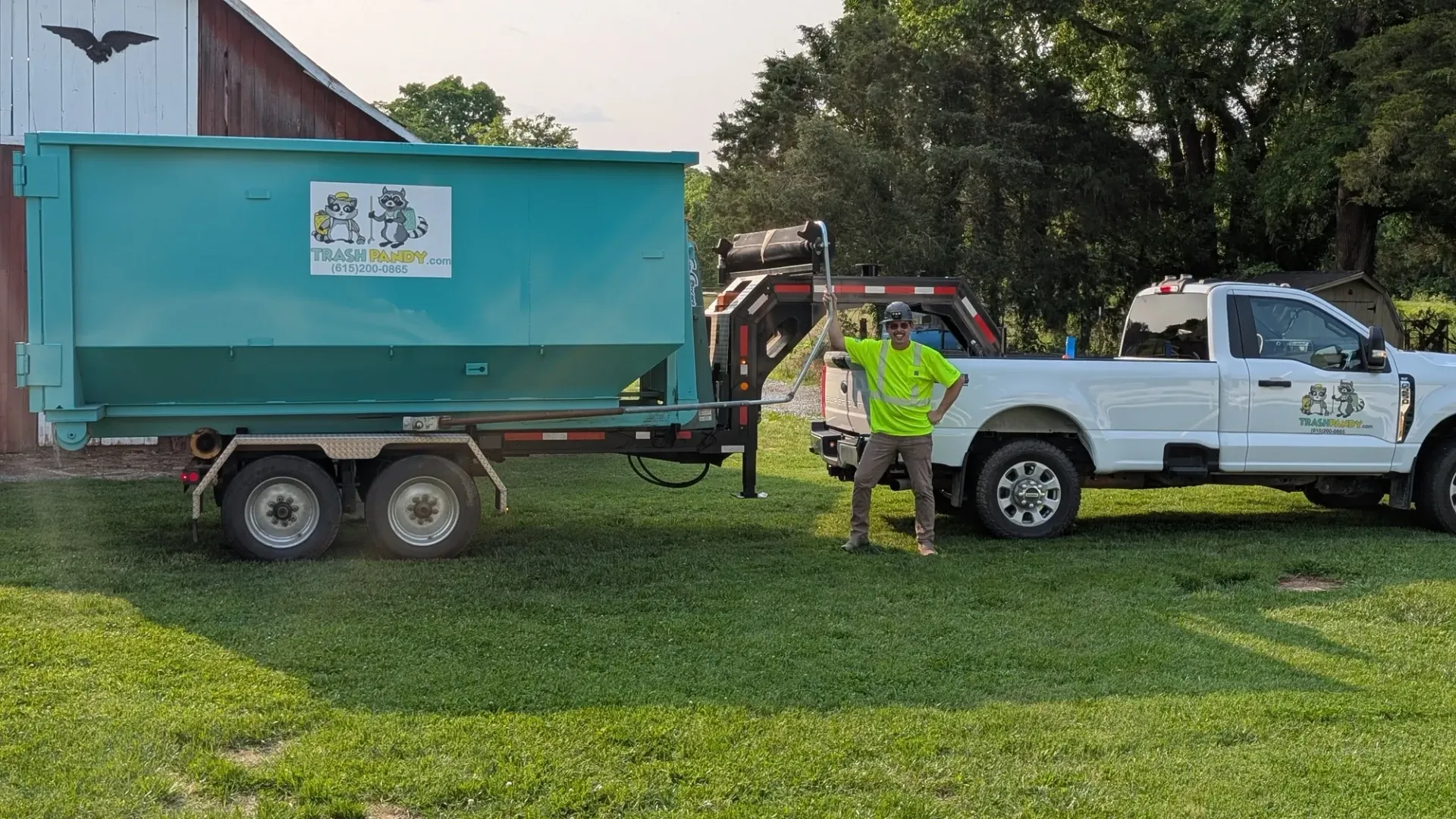 A dump truck with a green dumpster attached to it is parked in a parking lot.