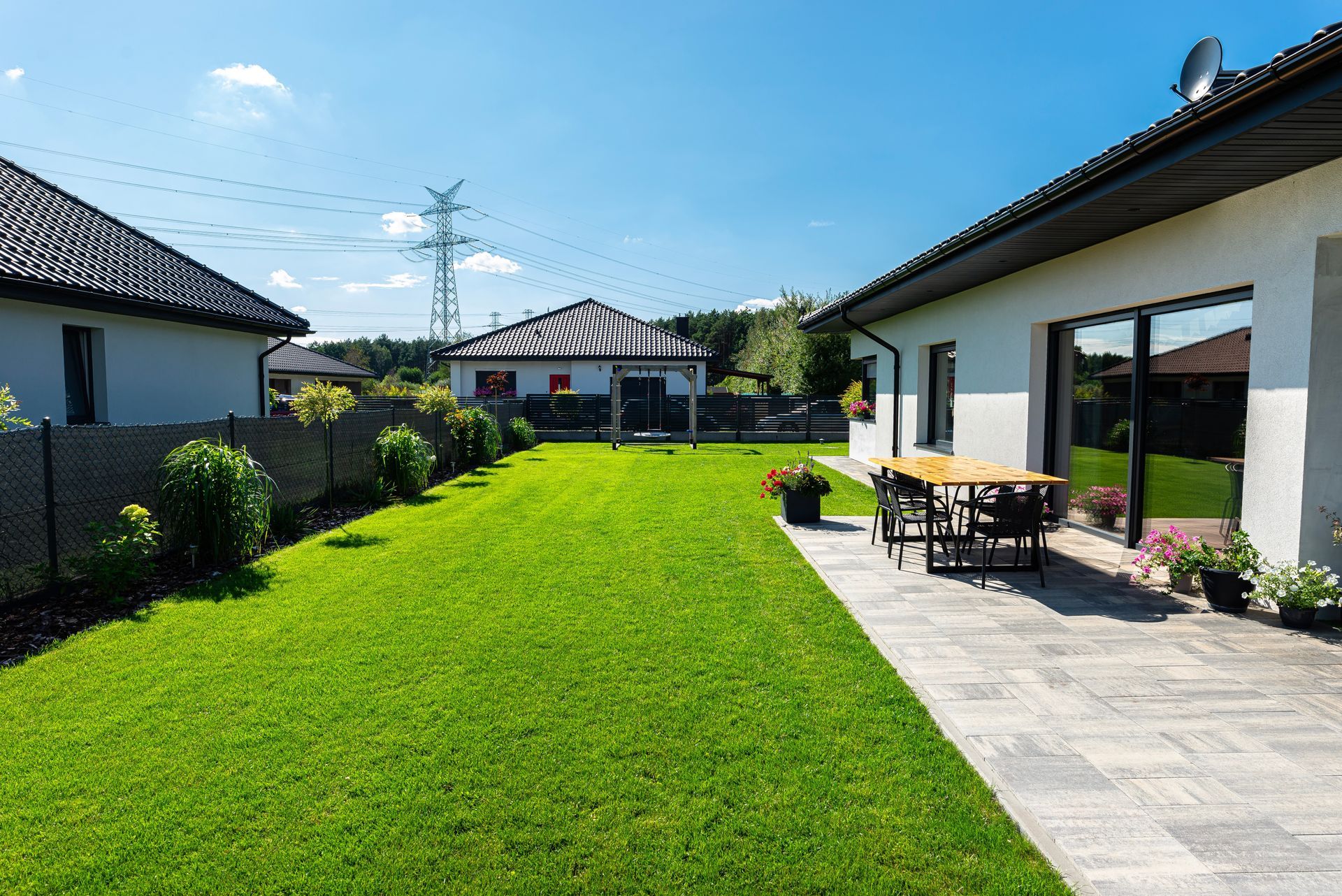 A house with a large lawn and a patio in front of it.